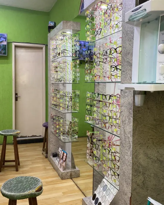 Parede de vitrines com armações na loja, ao lado de uma parede verde